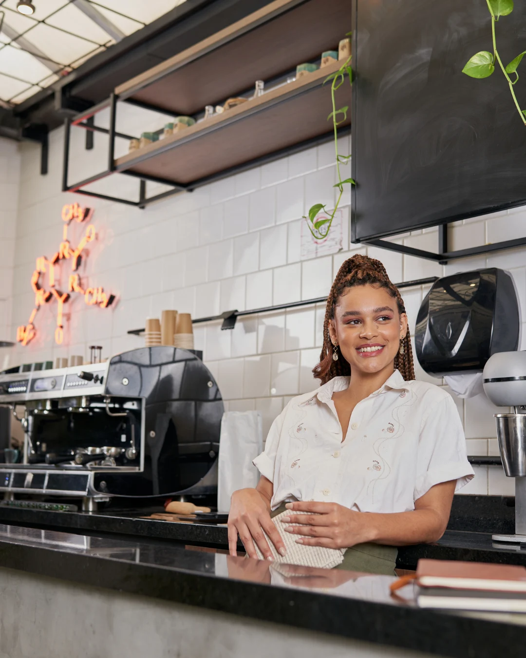 Empleada sonriente en una cafetería que ejemplifica la importancia de contratar un seguro local comercial para proteger el negocio