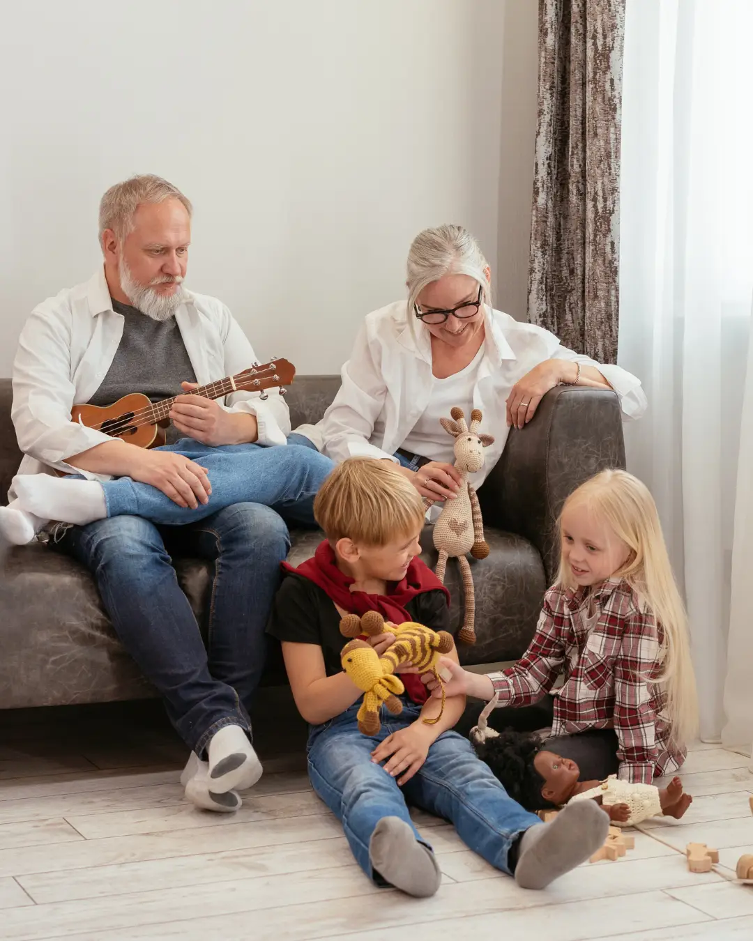 Abuelos compartiendo tiempo con sus nietos en casa y valorando cuánto cuesta un seguro de decesos para garantizar su bienestar futuro.