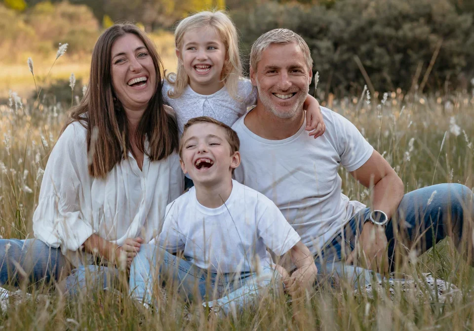 Familia feliz en el campo que representa la diferencia entre contenido y continente en un seguro de hogar, simbolizando el valor de proteger tanto la vivienda como sus bienes.