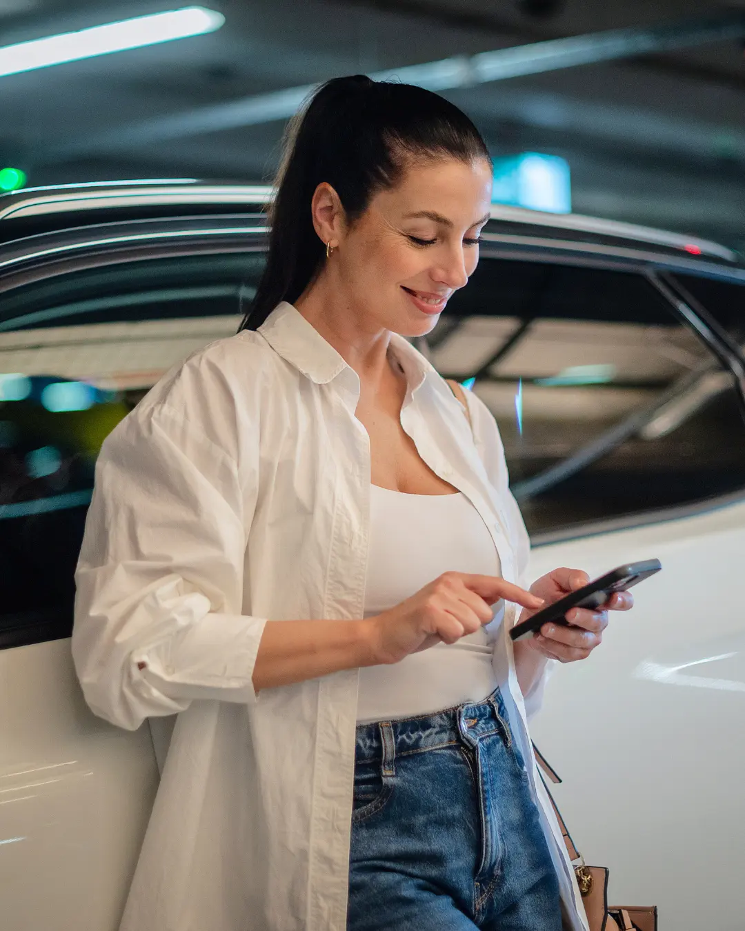 Mujer revisando en su móvil la póliza de coche para entender qué significa la franquicia en un seguro.