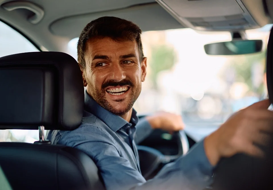 Conductor sonriendo mientras conduce, imagen ilustrativa para explicar qué significa la franquicia en un seguro.
