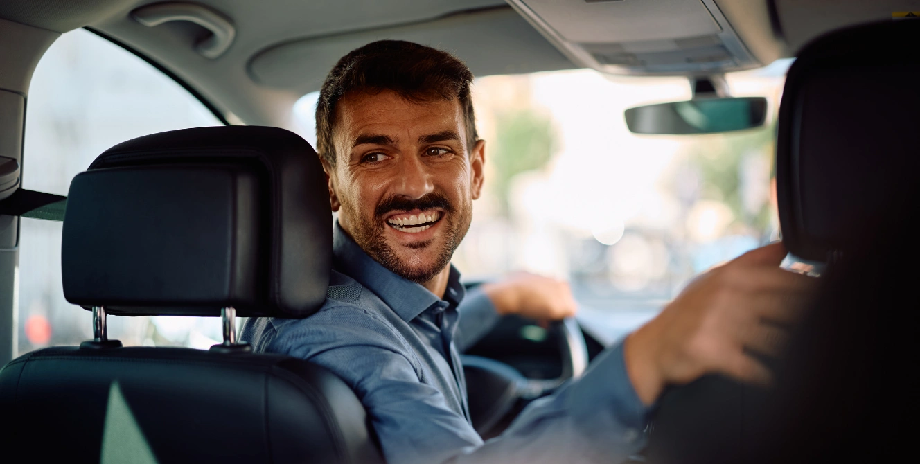 Conductor sonriendo mientras conduce, imagen ilustrativa para explicar qué significa la franquicia en un seguro.