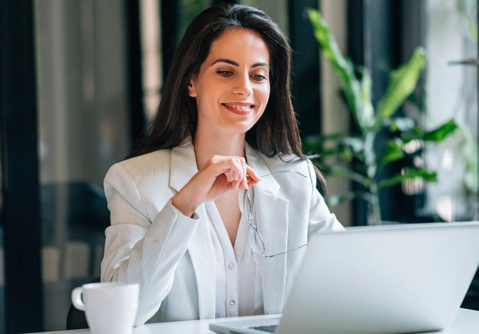 Empresaria trabajando en su ordenador analizando la diferencia entre sociedad anónima y sociedad limitada para crear una empresa.