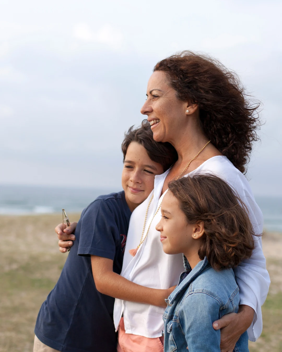Familia abrazada en la playa representando los tipos de seguros de vida y la protección económica ante imprevistos