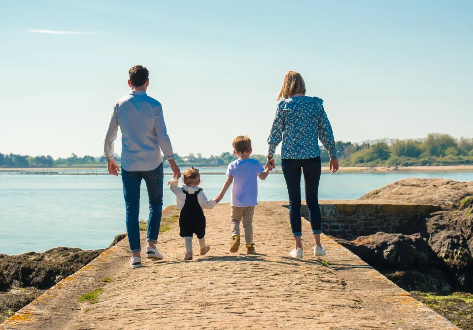 Familia caminando junto al mar representando los tipos de seguros de vida Ges Seguros y la protección familiar