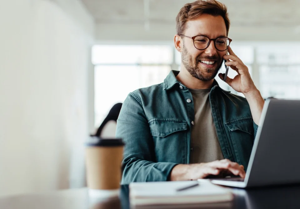 Profesional revisando la declaración de la renta de un autónomo desde su portátil mientras habla por teléfono