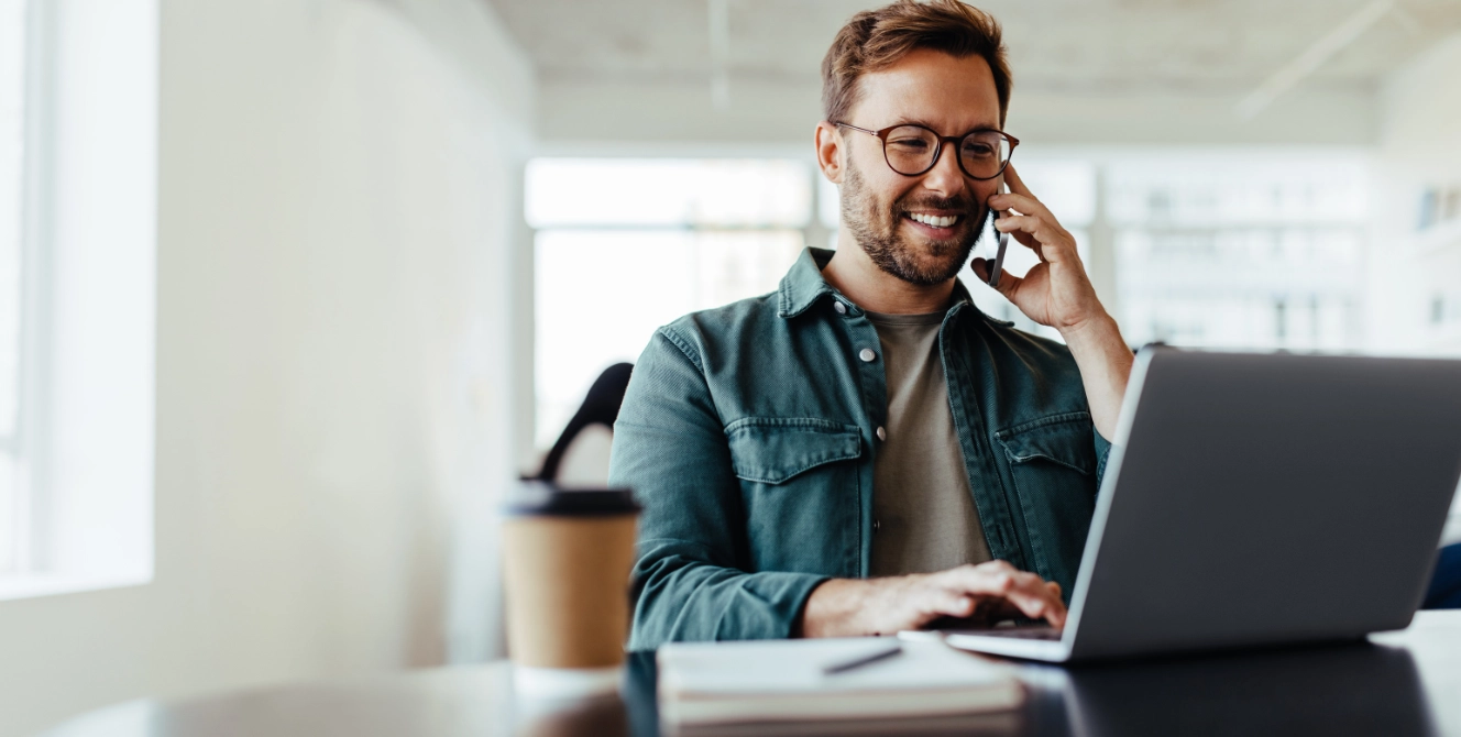 Profesional revisando la declaración de la renta de un autónomo desde su portátil mientras habla por teléfono